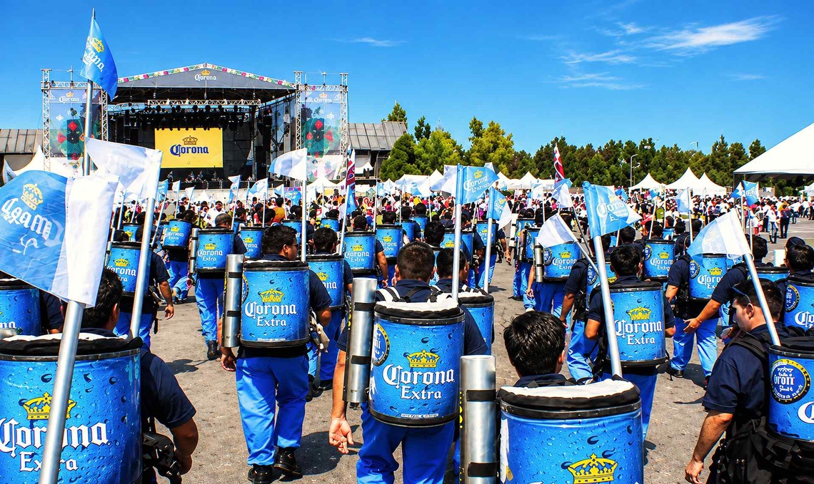 Promotionteam mit gebrandeten Bierrucksäcken bei einer großen Corona-Bierveranstaltung im Freien.